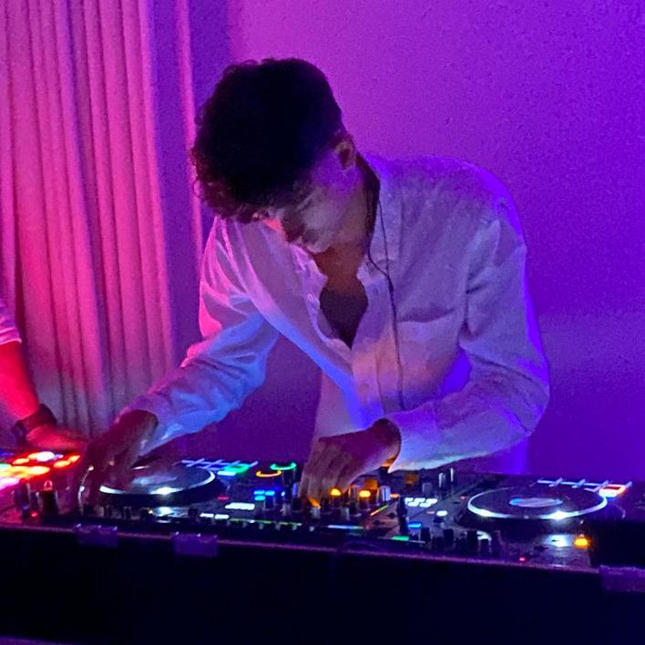 DJ Tuur behind the CDJs in purple and pink light